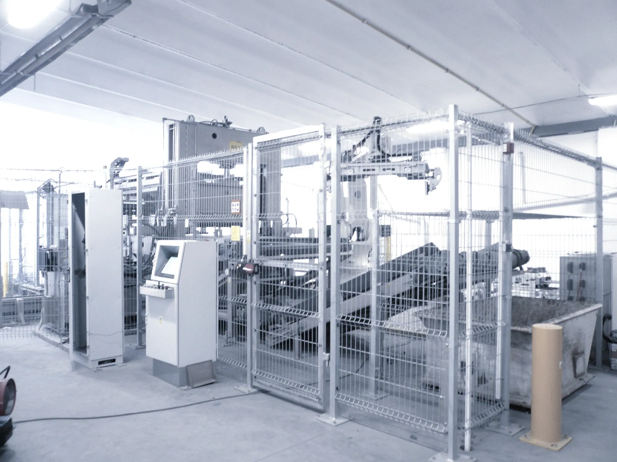 An automated production cell enclosed by safety fencing with an operator control station