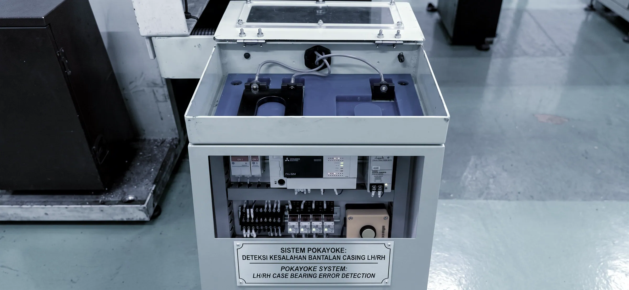 A poka-yoke detection unit mounted beside a machine, labelled for LH and RH case bearing error detection
