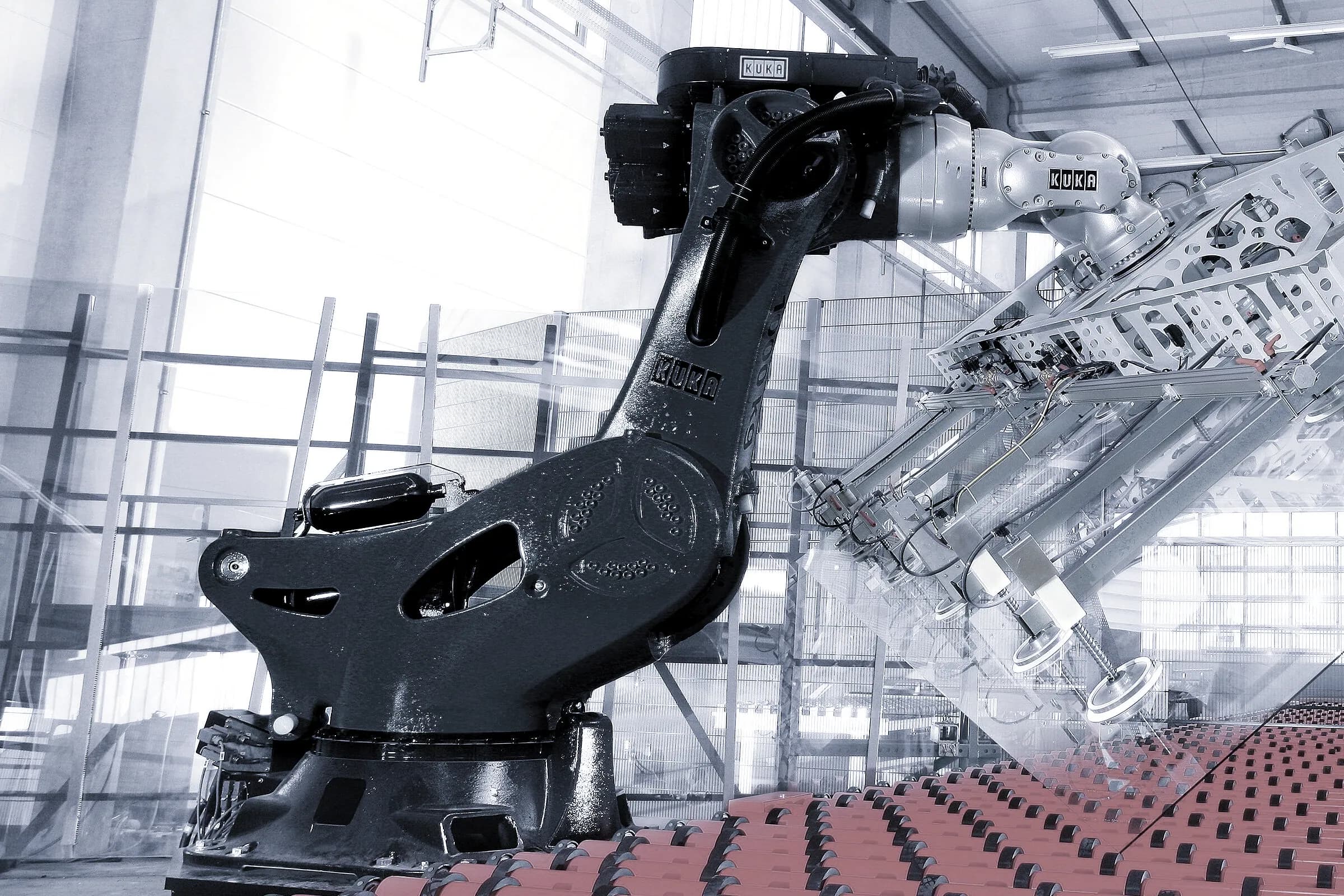 Servo-driven robotic manipulators positioning a metal component on a production line
